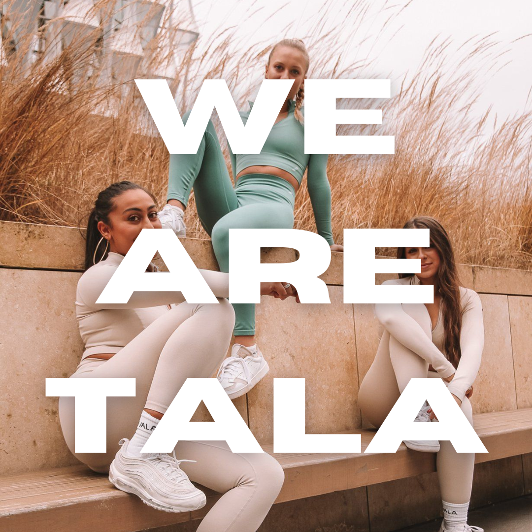 Blog Post about top ten independent female owned businesses written by Tide and Seek sustainable swimwear - image of three girls sat on a stone bench with pampas grass behind them wearing activewear by We Are Tala with white text written over the top saying ' We Are Tala'  
