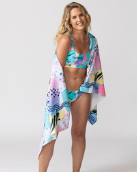 Tide and Seek sustainable swimwear saved by the bell beach towel wrapped around blonde model